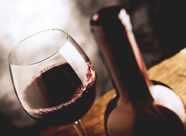 vin rouge dans un verre à côté de la bouteille