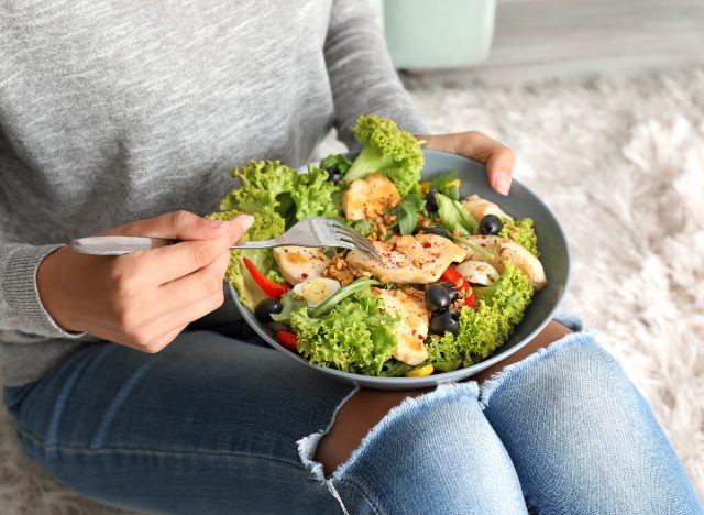 femme mangeant de la salade avec du poulet