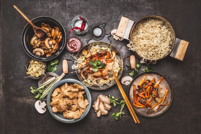 cuisine asiatique; wok avec nouilles, poulet et légumes avec épices et sauces