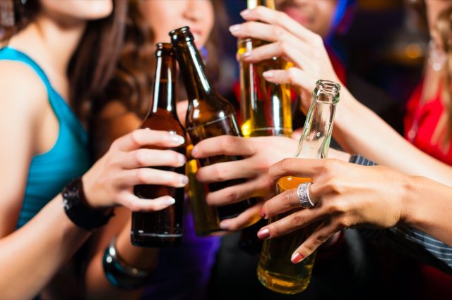 Groupe de fêtards - hommes et femmes - buvant de la bière dans un pub ou un bar