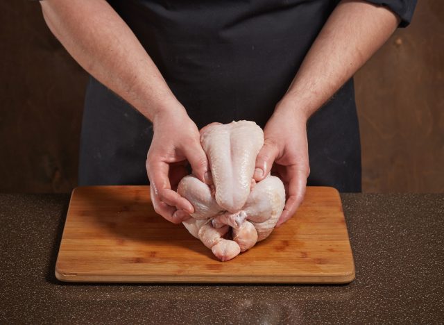 homme préparant du poulet cru
